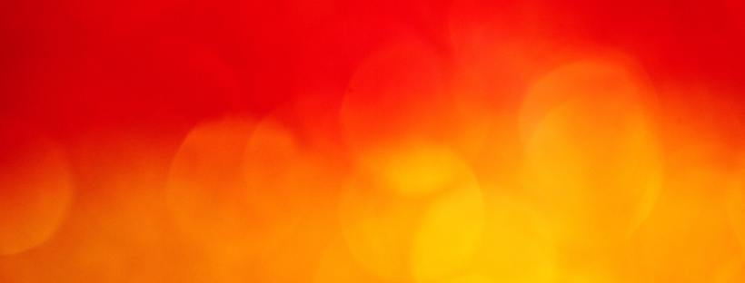 Stock abstract photo of yellow and orange bubbles or light against a red orange background. It looks hot and hazy.
